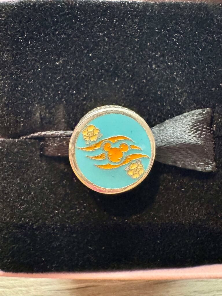 Bright blue enamel Disney mug-shaped pin with gold-tone Mickey Mouse and floral accents.