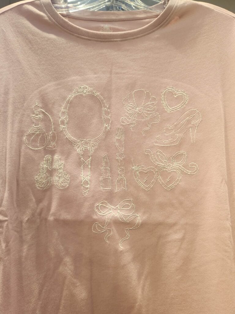 Embroidered fashion illustration with beauty, makeup, and shoe icons, perfect for Disney fashion lovers.