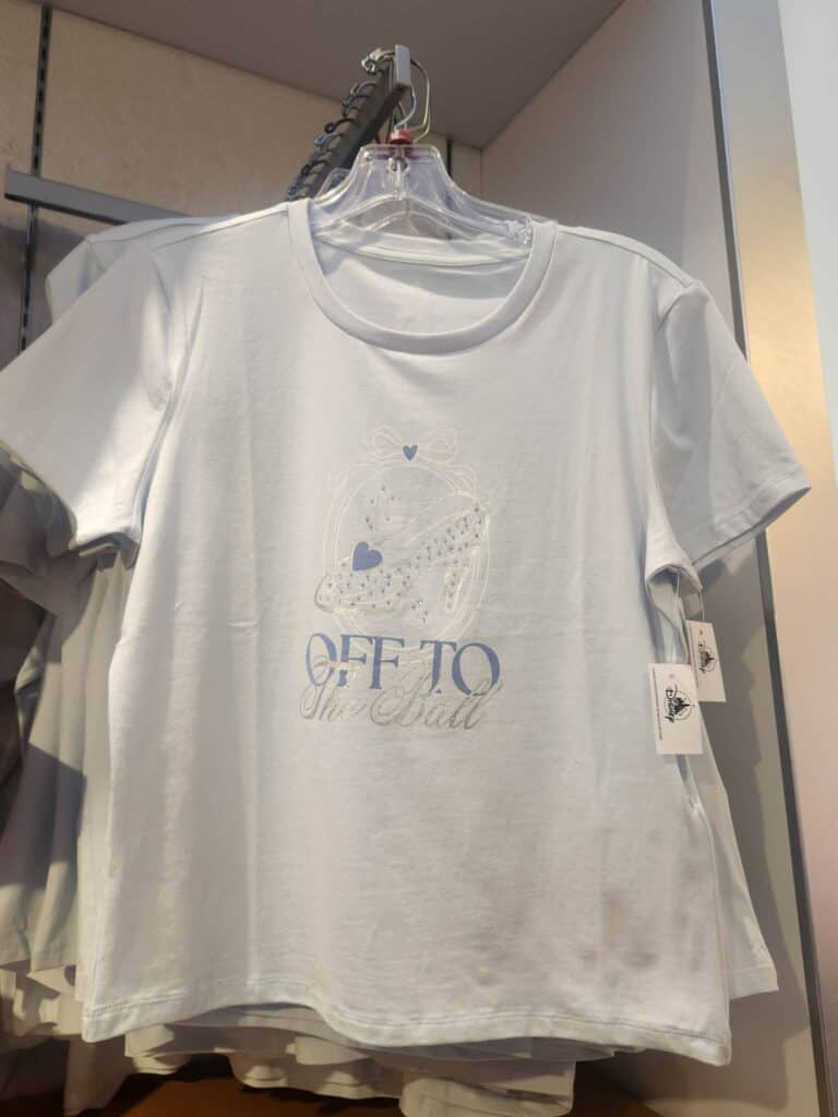 White Disney T-shirt with 'Off To Shoe Ball' design, sparkly accents, and Disney branding.