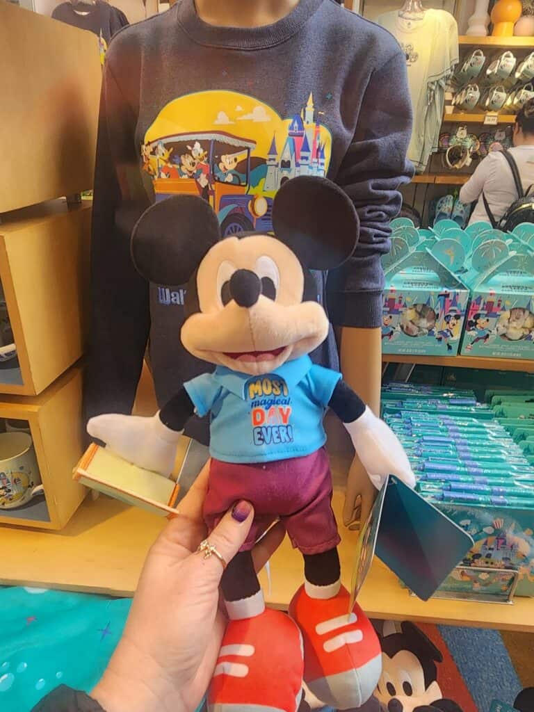 Mickey Mouse plush in blue shirt and red shoes, perfect Disney gift or decor.