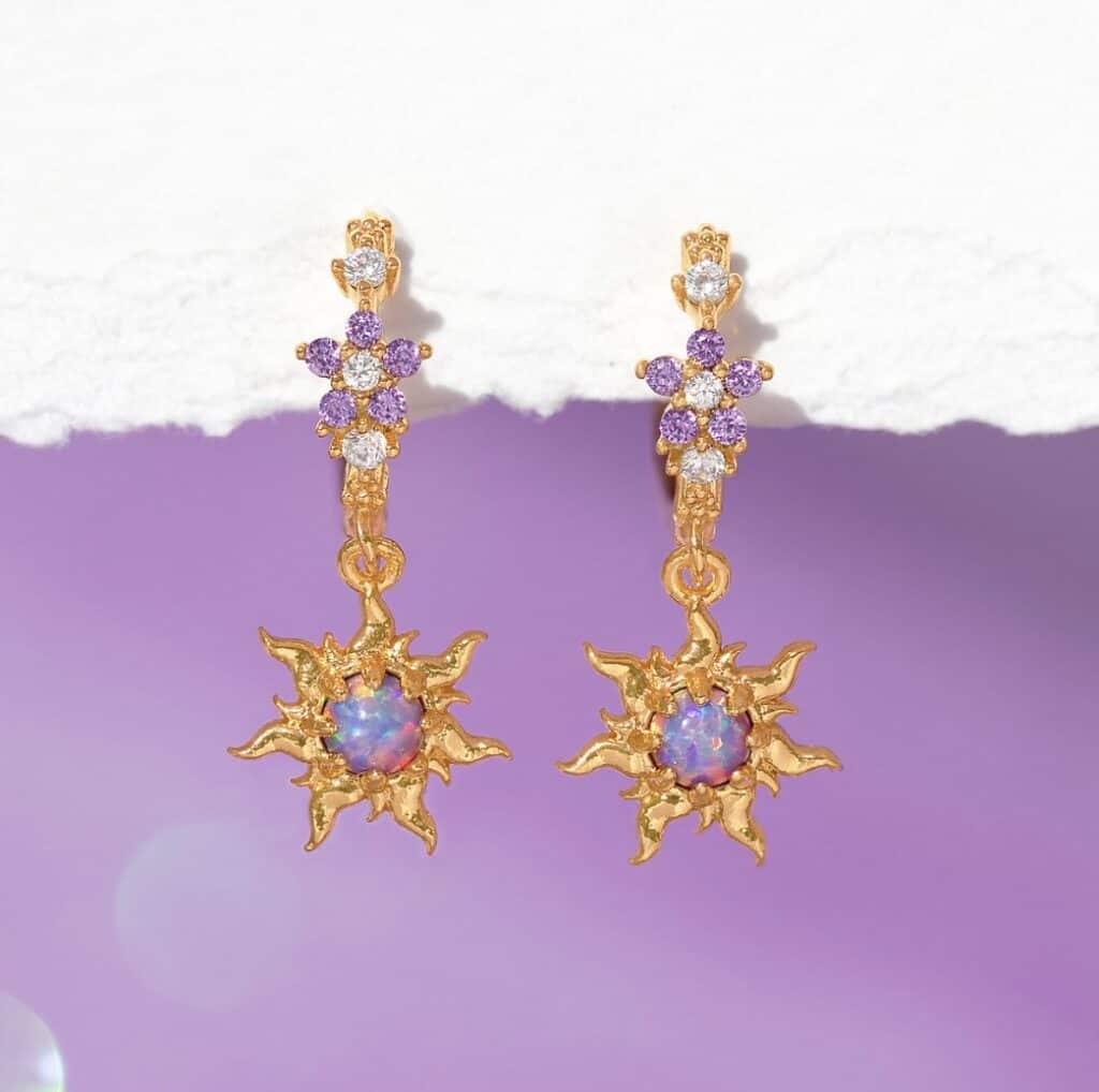 Elegant Disney-inspired sun and gemstone earrings with purple and white crystals.