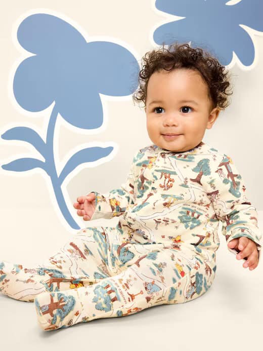 Adorable baby wearing colorful Disney-themed pajamas with woodland and adventure prints.
