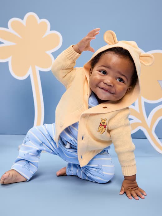 Adorable baby boy wearing a Winnie the Pooh hoodie with bear ears, perfect for Disney-themed baby outfits.