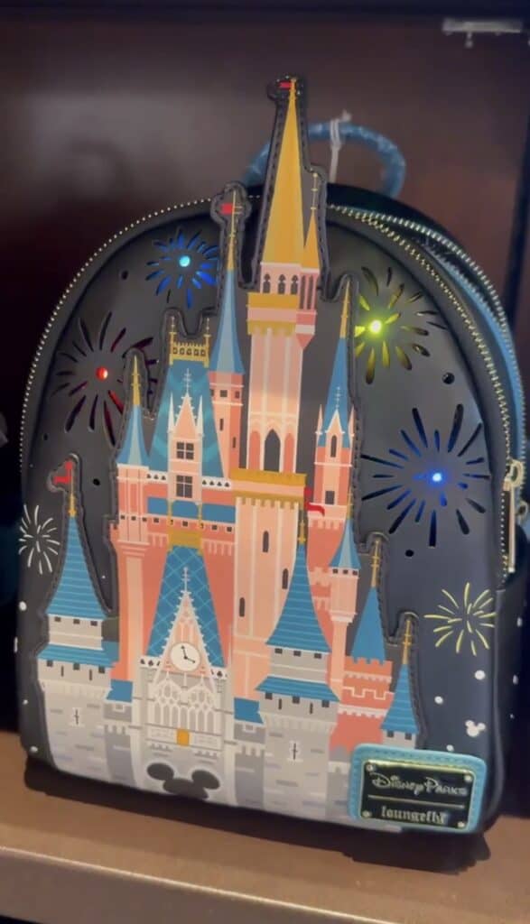 Colorful Disney castle backpack featuring illuminated fireworks display and classic castle design.