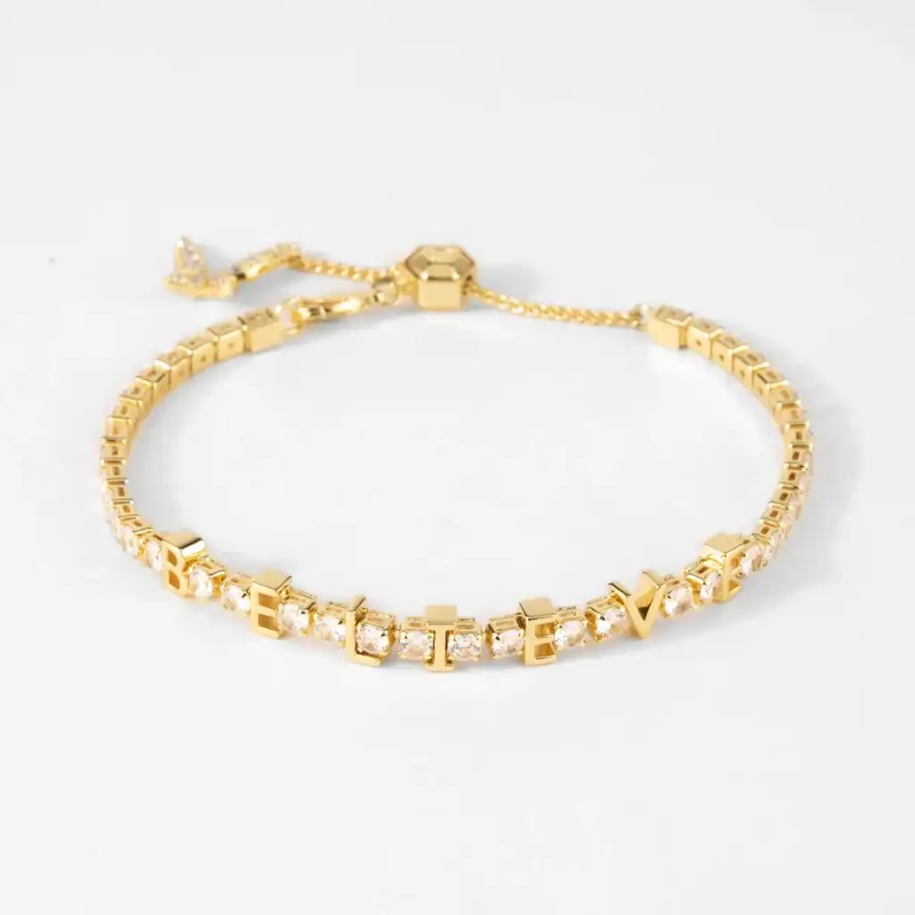 Gold bracelet with crystal-studded "BELIEVE" letters, perfect for Disney fans.