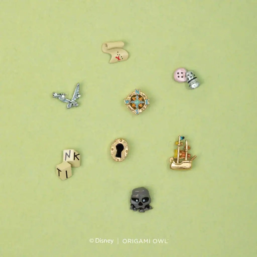 Colorful Disney-themed jewelry charms and pins on light green background.