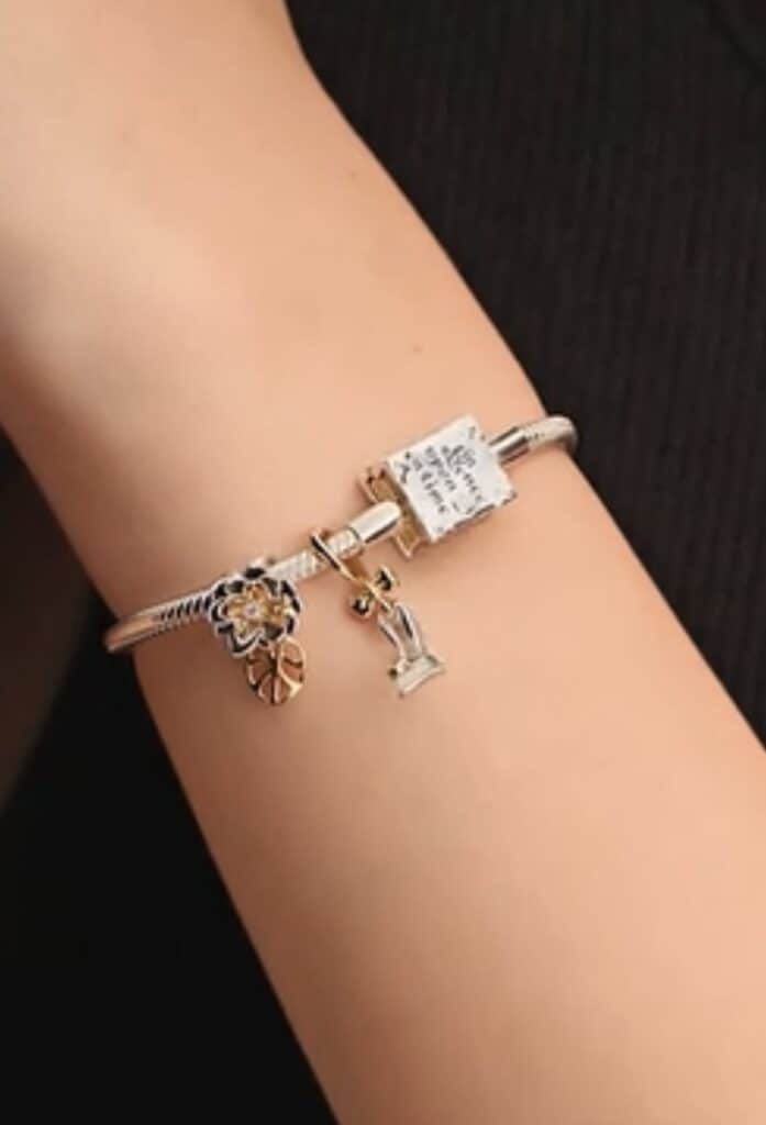 Elegant silver and gold charm bracelet with Disney-inspired charms.