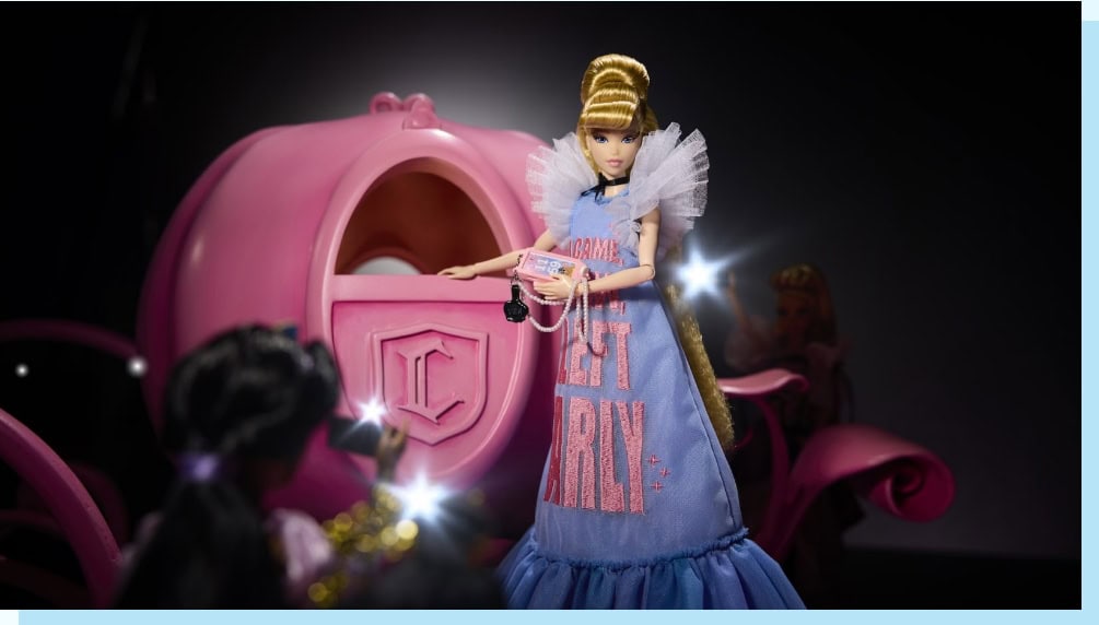 Enchanted Disney fashion doll in a letter girl dress with a pink carriage backdrop, perfect for Disney fan collectibles and fashion enthusiasts.