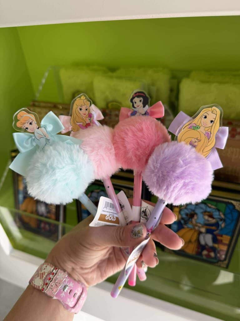 Colorful plush Disney princess pens with character toppers and pastel bows, perfect for Disney fans and stationery lovers.