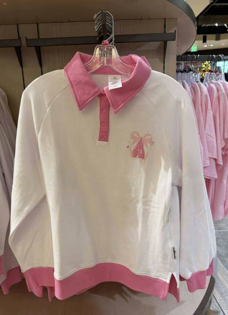 Pink and white Disney-themed princess sweatshirt with castle and bow logo.
