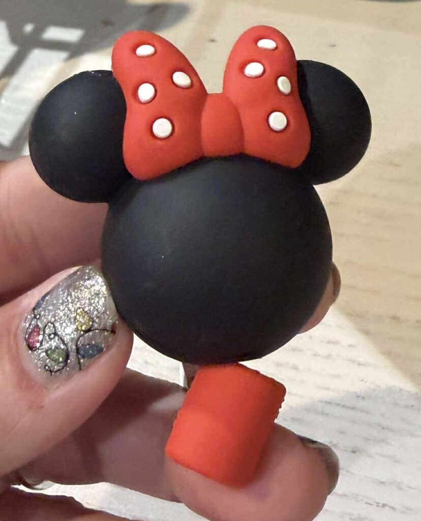 Vibrant Minnie Mouse themed cheesecake with iconic red bow and black ears, perfect for Disney fans.