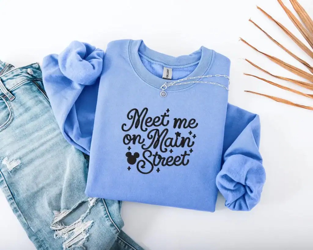 Bright blue crewneck with playful typography and Mickey mouse icon, ideal for casual wear.