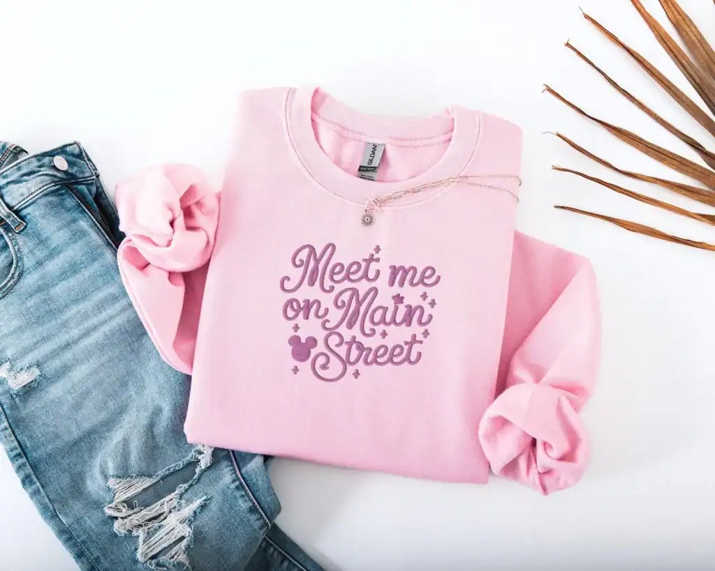Pink sweatshirt with Disney-themed text and Mouse Ears design, perfect for Disney fans and casual wear.