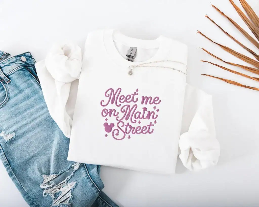 Disney-themed stylish sweatshirt for Disney fans, featuring "Meet me on Main Street" graphic for casual wear.