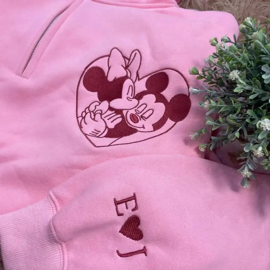 Embroidered Minnie Mouse face on a pink hoodie featuring Disney-inspired design.