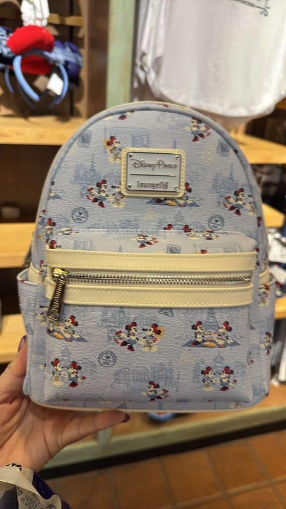 Light blue Disney Loungefly backpack with Mickey Mouse print and gold zipper details.