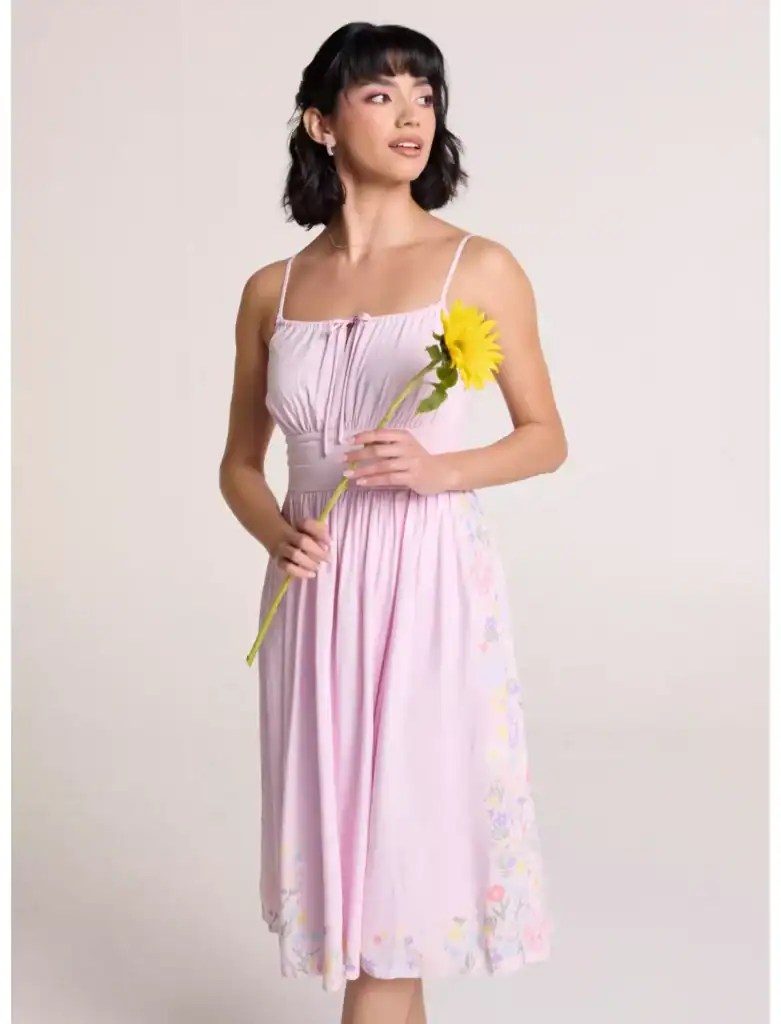 Woman in pink Disney princess-inspired dress holding a sunflower.