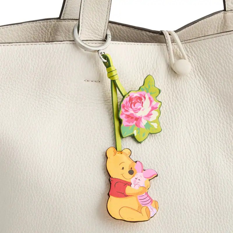 Winnie the Pooh bag charm featuring a pink flower and adorable character design.