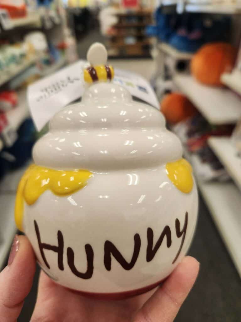 Decorative honey pot cookie jar with bee accent, perfect for kitchen decor or as a gift.