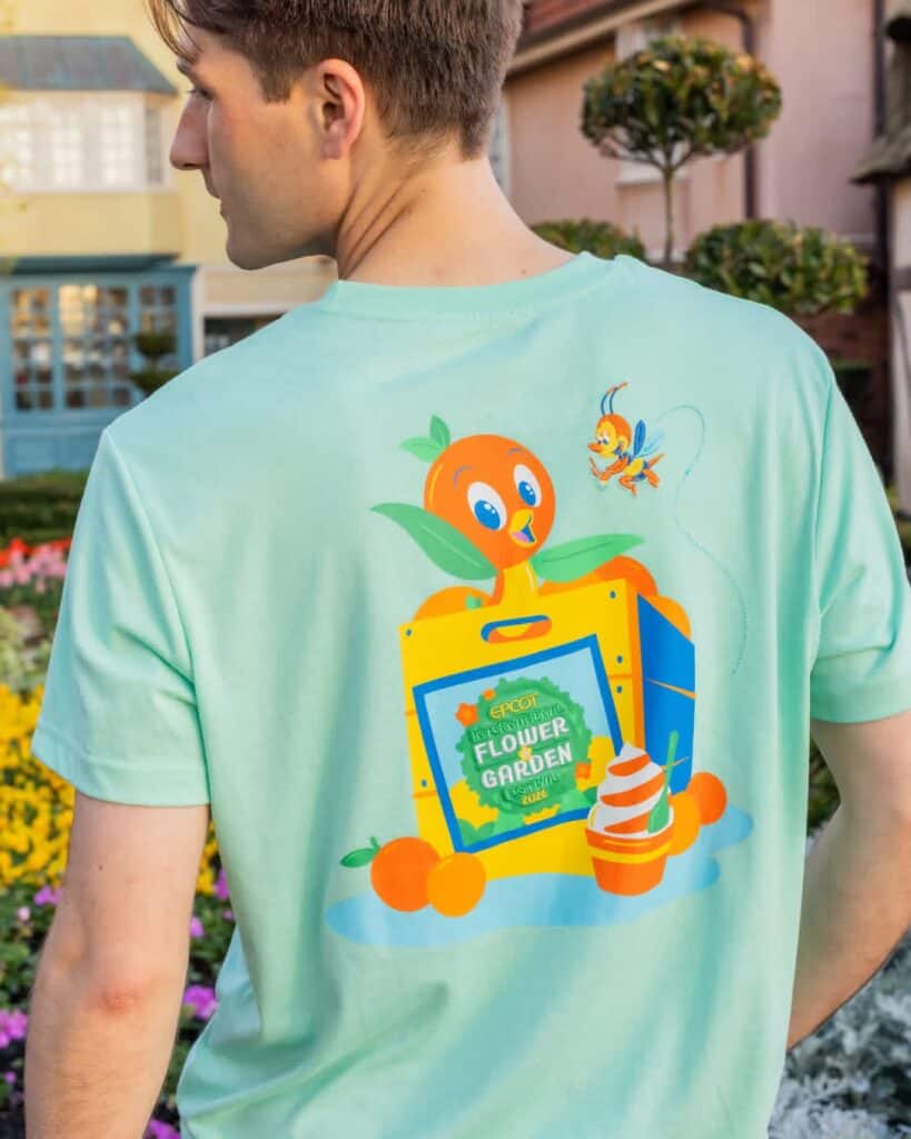 Young man wearing a Disney Flower Garden themed T-shirt outdoors.