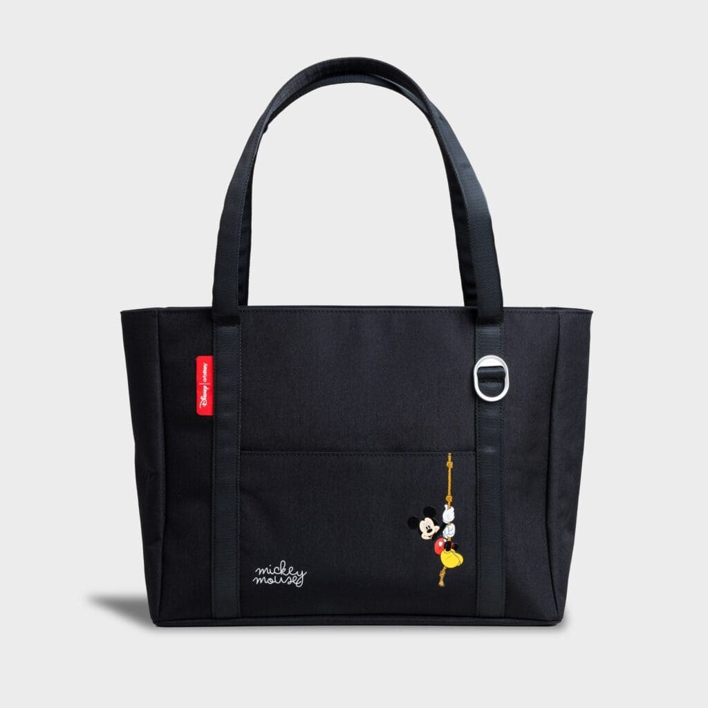 Black Mickey Mouse tote bag with keychain and logo detail.