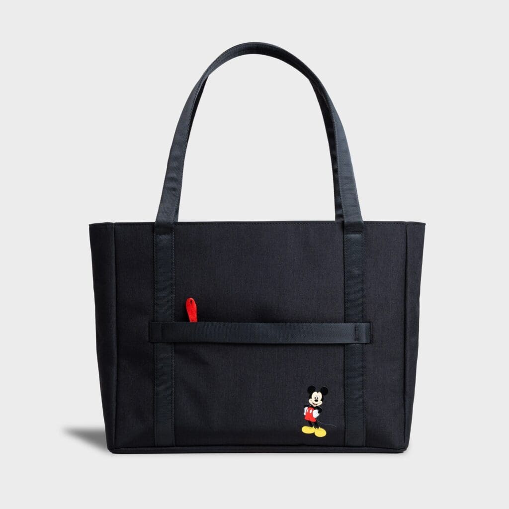 Black tote bag featuring Mickey Mouse embroidery and front pocket.