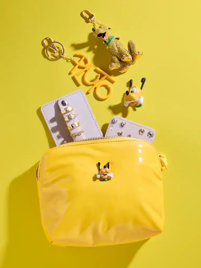 Bright yellow Disney-themed bag with Mickey and Pluto charms on a yellow background.