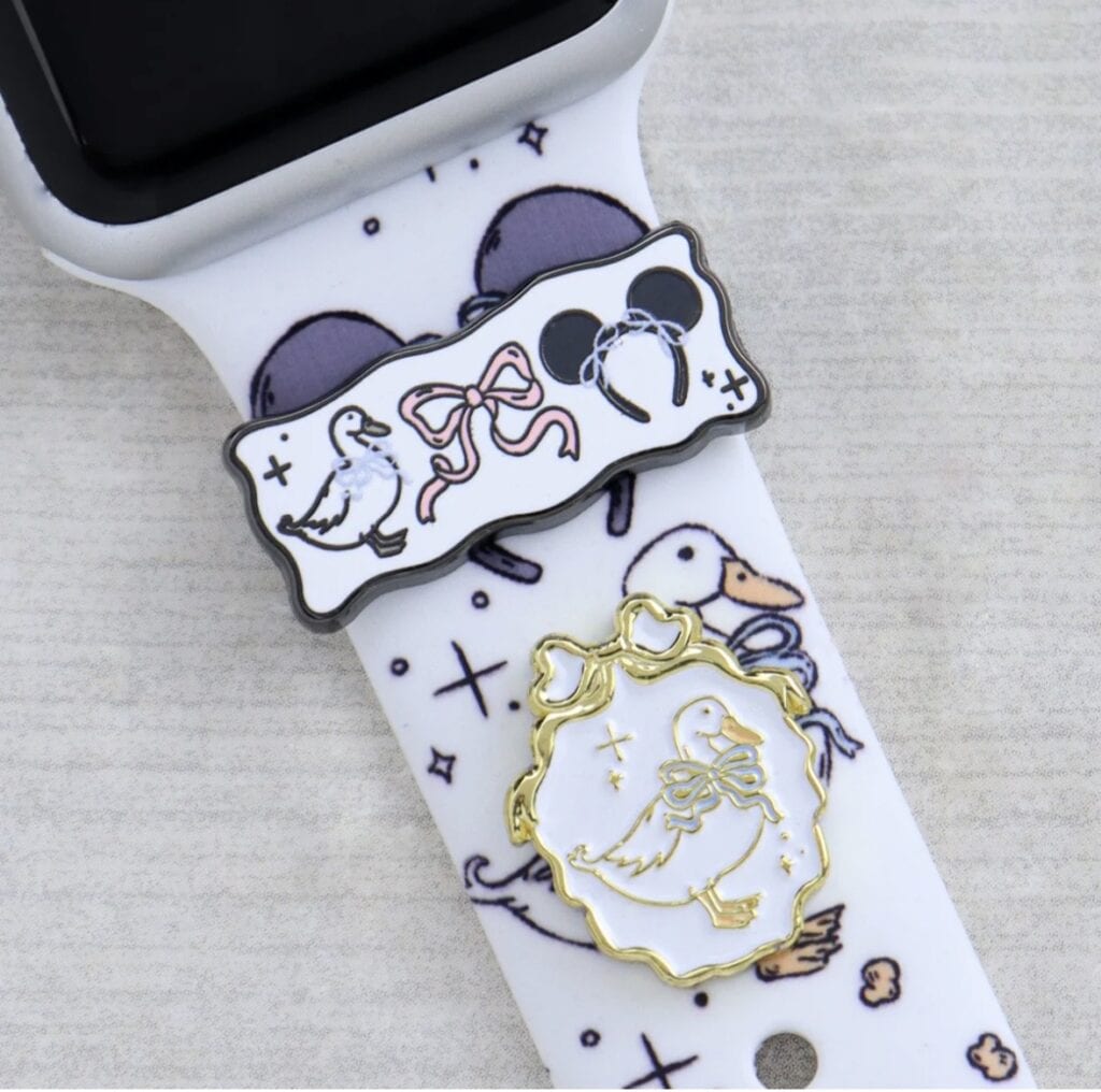 Cute duckling charm accessory for Disney-themed smartwatch strap.