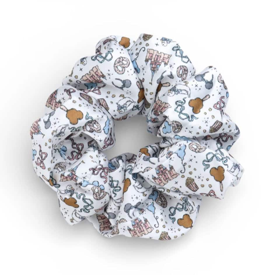 Disney-themed fabric scrunchie with playful print of castles, Mickey ears, and accessories.
