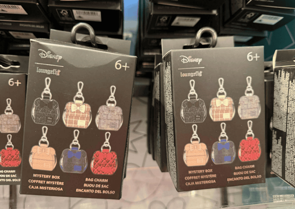 Colorful Disney Loungefly bag charms with mystery box packaging, perfect for Disney fans and collectible accessories.