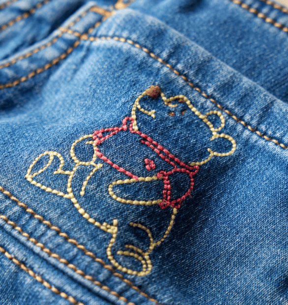 Embroidered Winnie the Pooh on denim pocket, celebrating Disney's 100 years of Pooh.