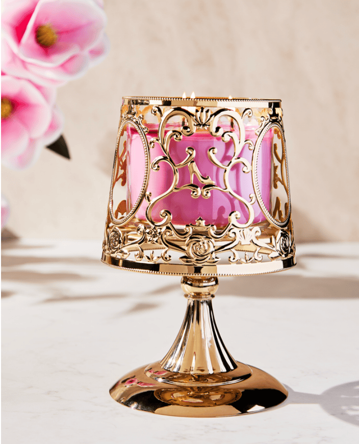 Inspired decorative candle holder with ornate gold design and pink glass.