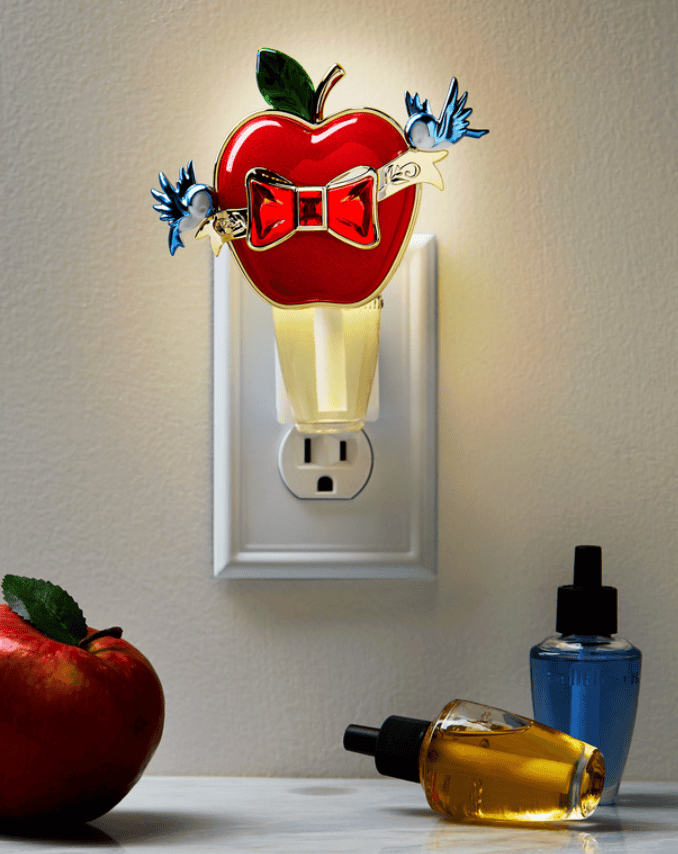 Bright apple night light with Disney bow and birds, plug into wall outlet.
