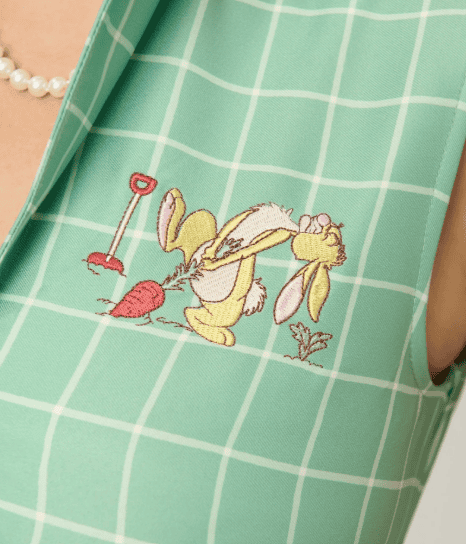 Cute Daisy Duck embroidery on green checkered apron.