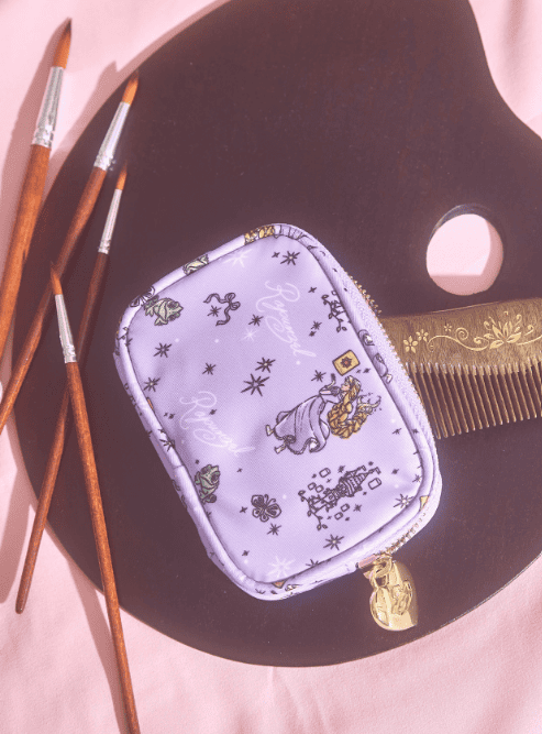 Small lavender makeup pouch with Disney princess and crown designs, gold zipper, and charm.