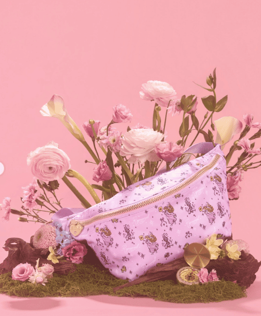 Disney floral bag with pink flowers, plush toys, and accessories on moss.