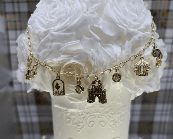 Gold Disney charm necklace with iconic character and castle pendants, perfect for Disney fans and fa.