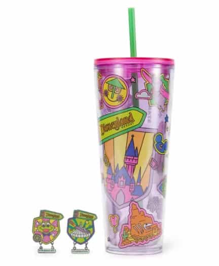 Themed Disney tumbler with green straw and colorful castle design.