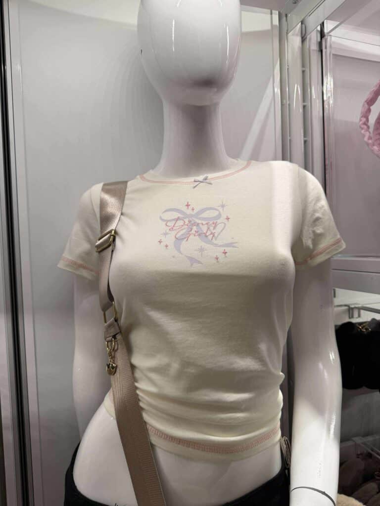 White Disney-themed T-shirt with pastel design on mannequin.
