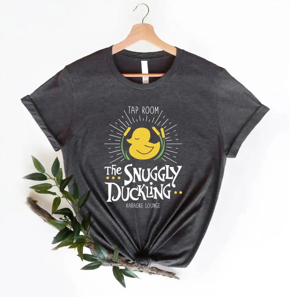 Dark gray T-shirt featuring the Snuggly Duckling logo from Disney's Tangled, perfect for casual Tap.
