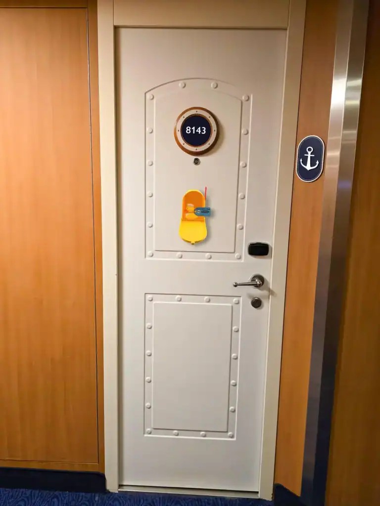 Decorated cruise ship door with Disney-themed items, including a yellow duck and mini Disney character.