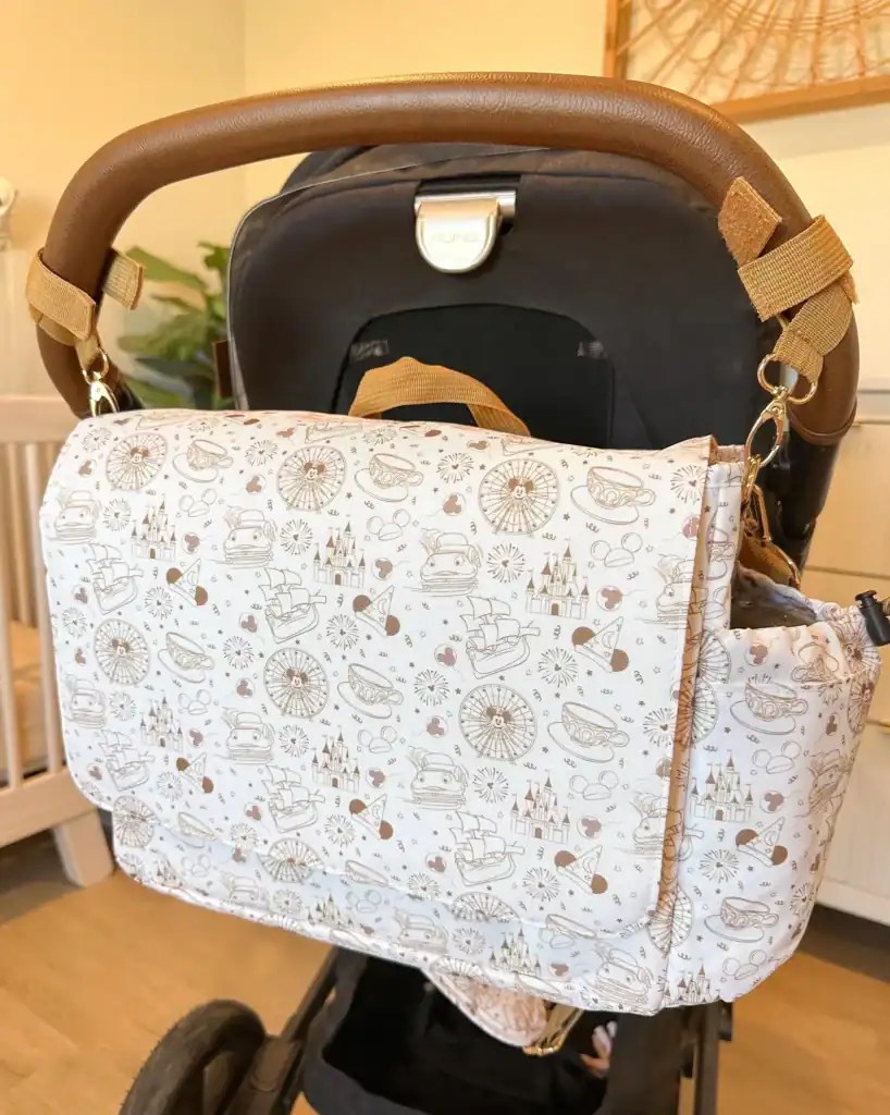 Baby stroller organizer featuring Disney-themed pattern and adjustable straps.