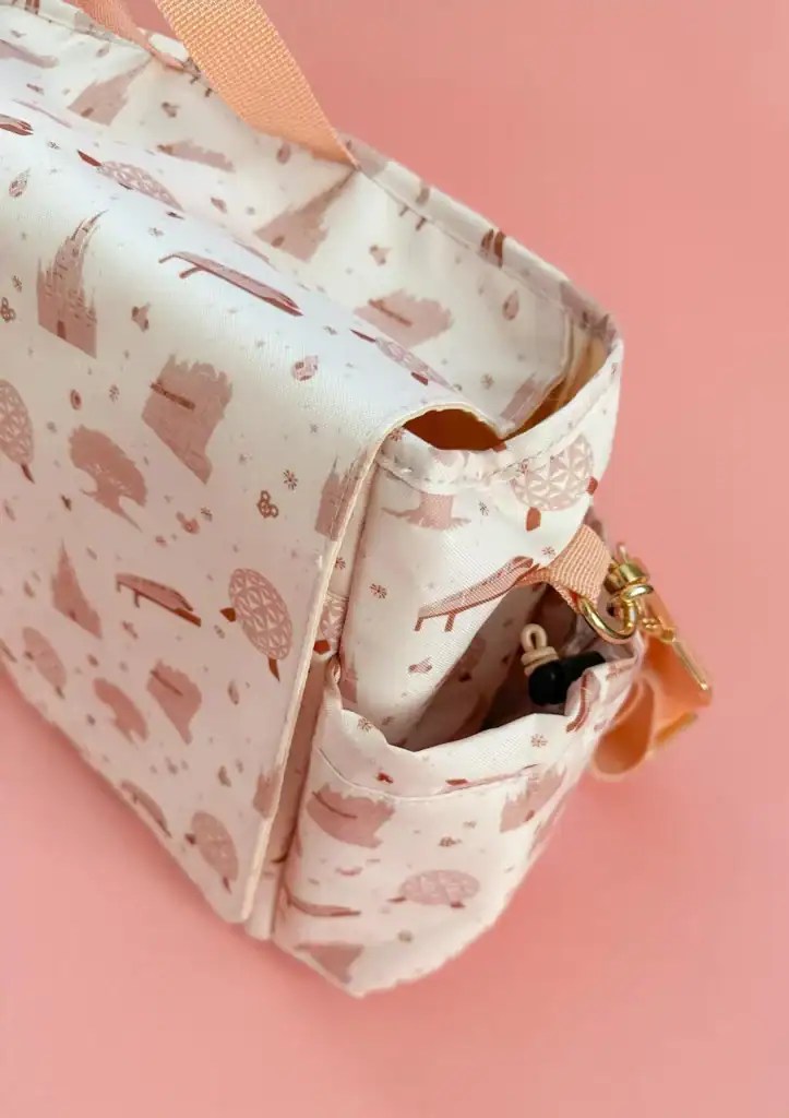 Pink Disney-themed makeup bag with compartments and gold zipper.