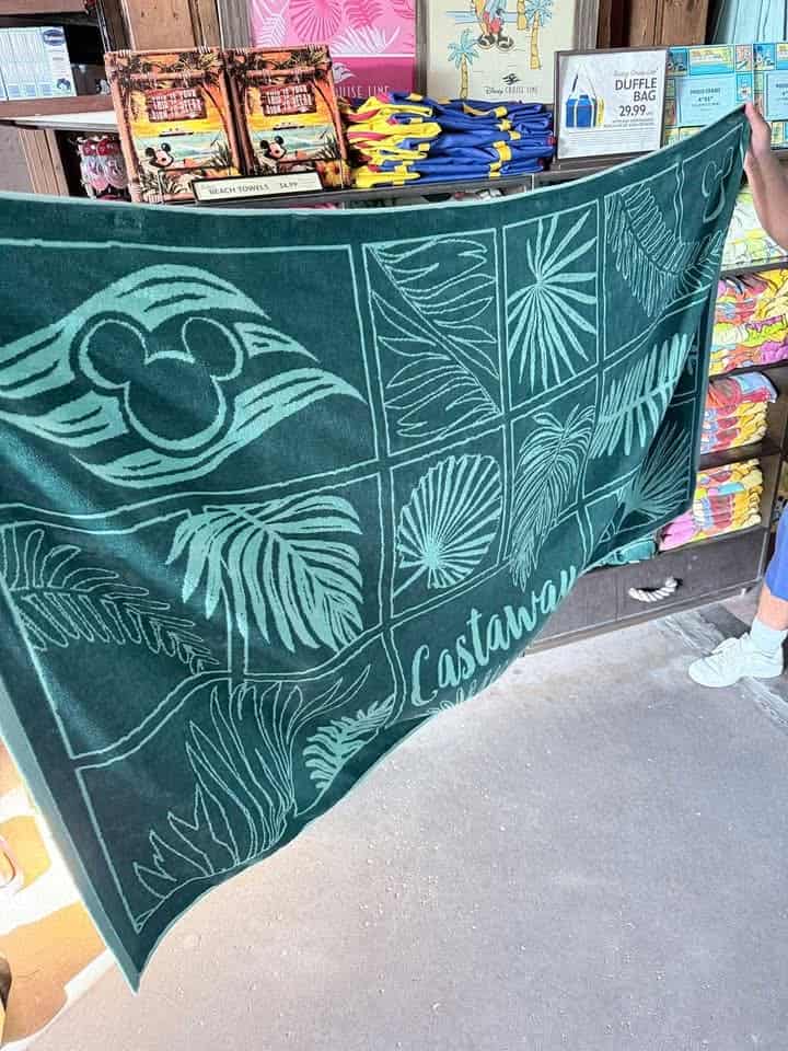 Disney Castaway Cay beach towel with tropical leaf and Mickey logo design.