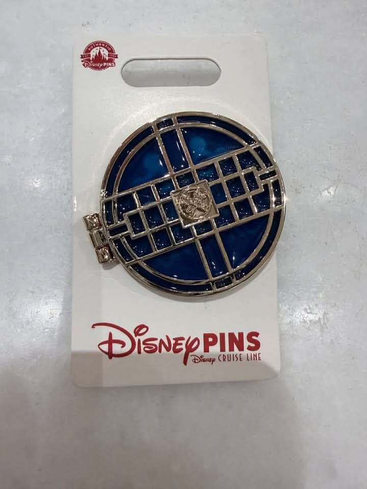 Disney Pins circular pin featuring a blue background and gold geometric design.
