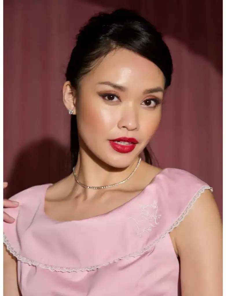 Disney fashionista wearing a pink embroidered dress with lace accents.