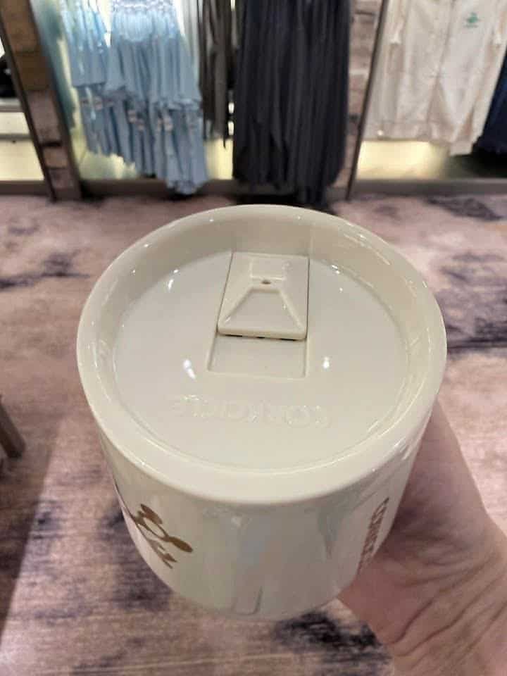 Reusable coffee cup with Disney logo, eco-friendly travel mug.