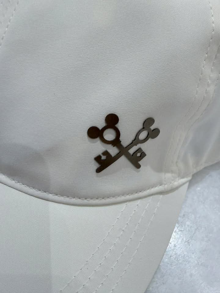 White cap with Disney-inspired key logo embroidery.