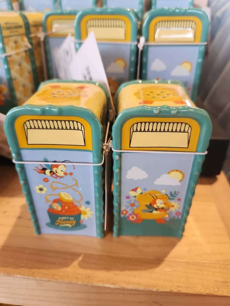 Colorful Winnie the Pooh-themed lunchbox with honey pot and cloud design.