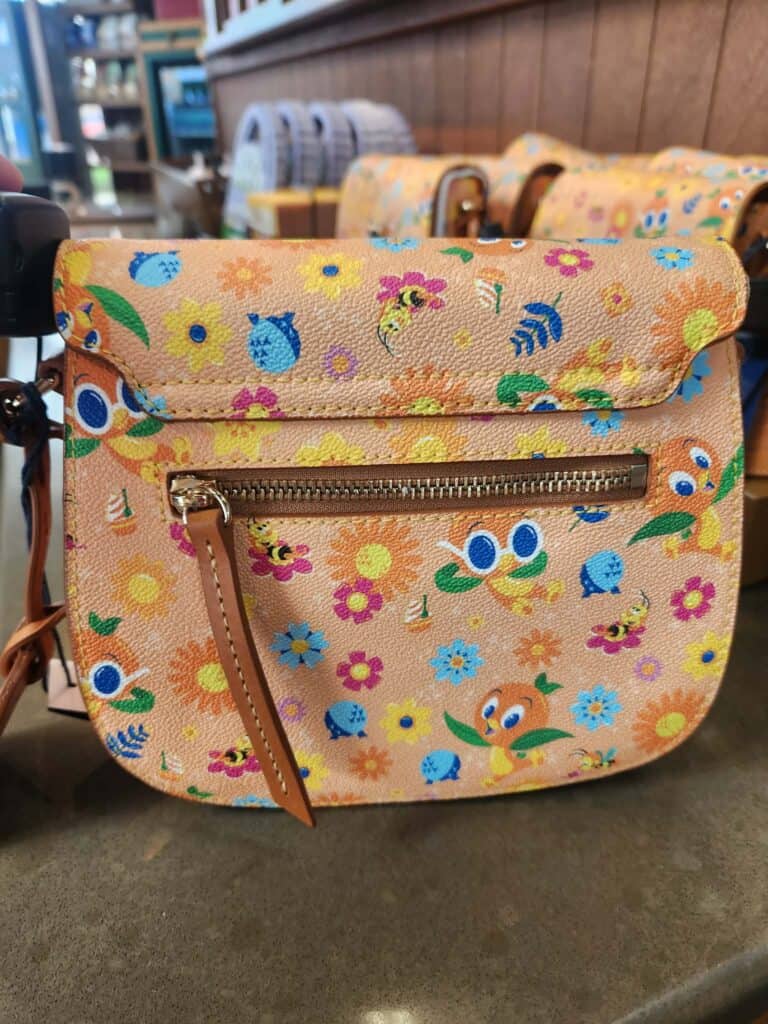 Colorful Disney-themed floral bag with character prints and zipper pocket.